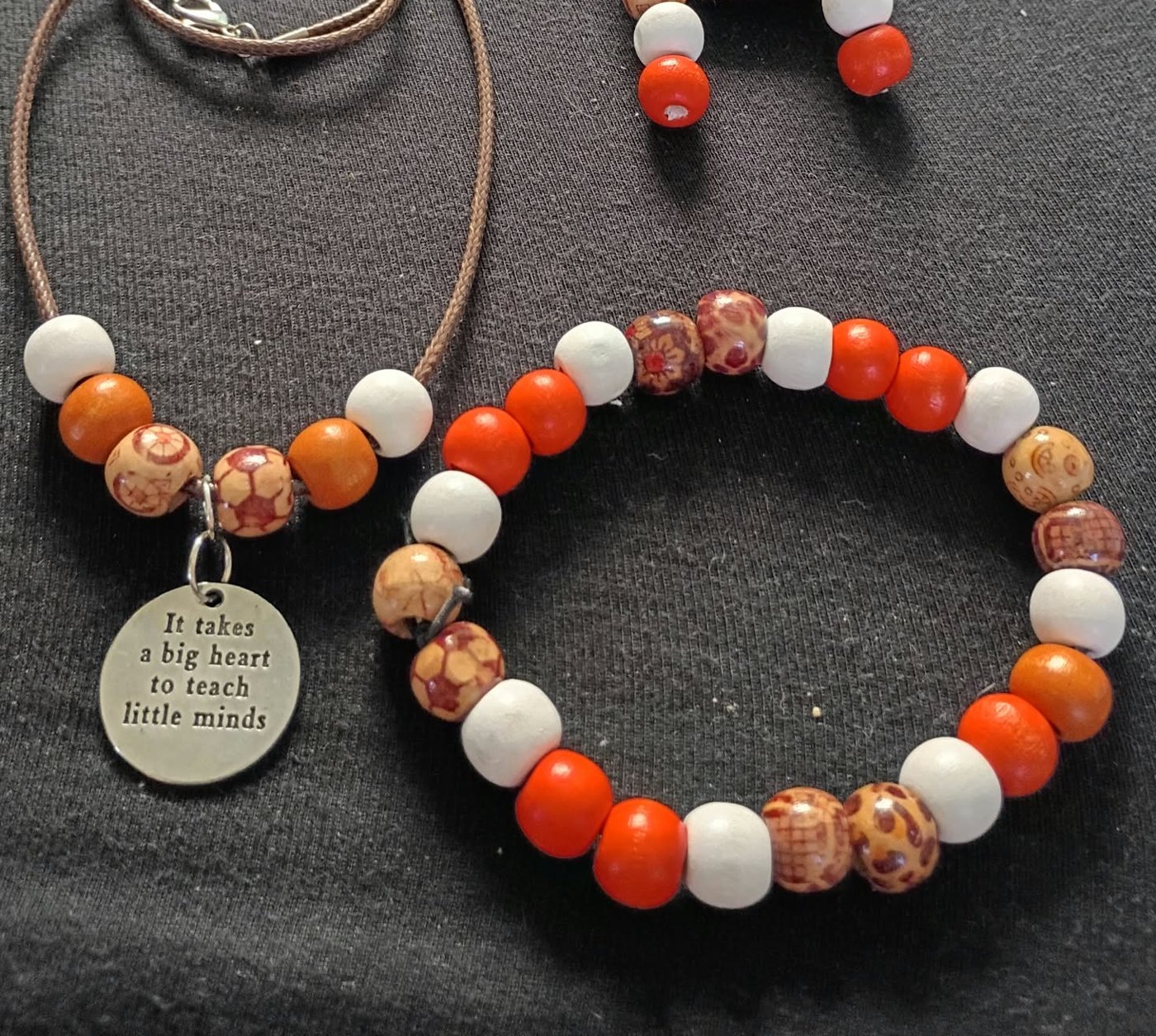Necklace, bracelet and earrings of orange, white and patterned wood beads